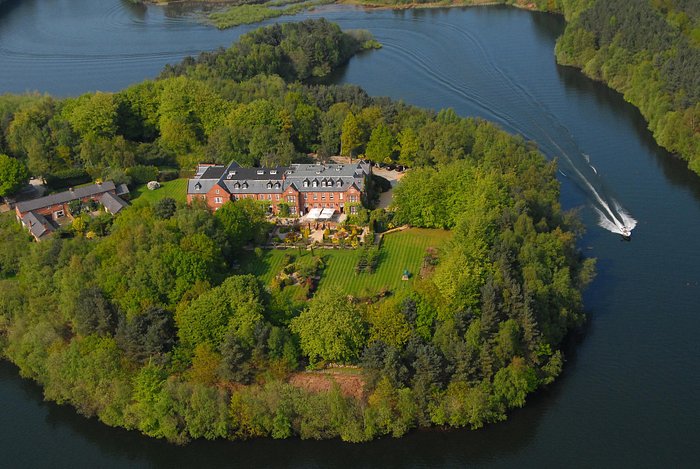 Overlooking view of Nunsmere Hall surrounded by a lake 